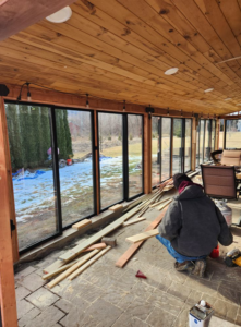 A worker installing large windows in a sunroom addition by Zig's Home Improvements in Reading, PA.