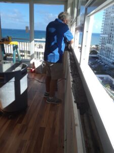A construction worker installing a window frame or railing by Corley Construction Inc in Fort Lauderdale, FL