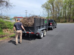A worker loading branches and yard waste into a junk removal trailer for Junk Runner, LLC in East Berlin, PA.