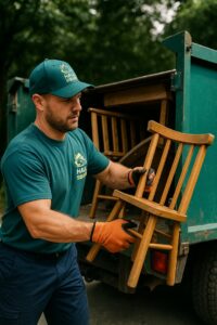 A Haul Squad team member loading old wooden chairs into a junk removal truck in Allentown, PA.