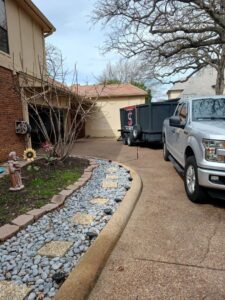 A Junk Something llc worker loading boxes into a trailer full of junk in Dallas, TX.