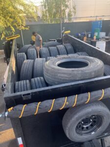 A worker loading old tires into a dump trailer, showcasing a junk removal service by MGM Junk Removal in Las Vegas, NV