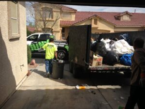 A Junk Control worker loading trash into a junk removal truck, demonstrating efficient service in Henderson, NV.