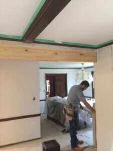 A worker measuring a doorway opening during framing and drywall work by Farnsworth Interiors Drywall and Plaster in Akron, OH