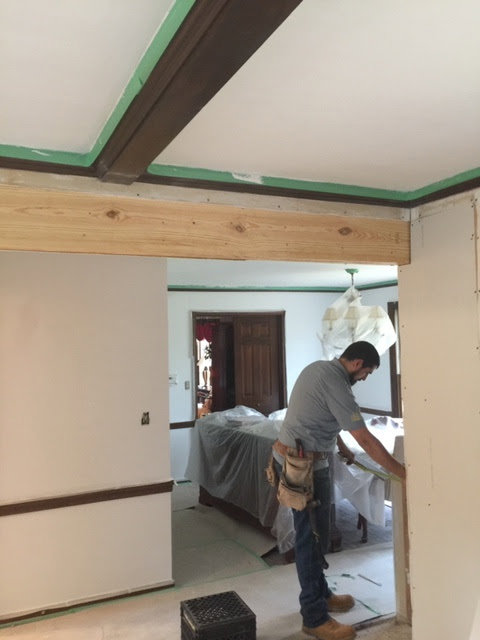 A worker measuring a doorway opening during framing and drywall work by Farnsworth Interiors Drywall and Plaster in Akron, OH