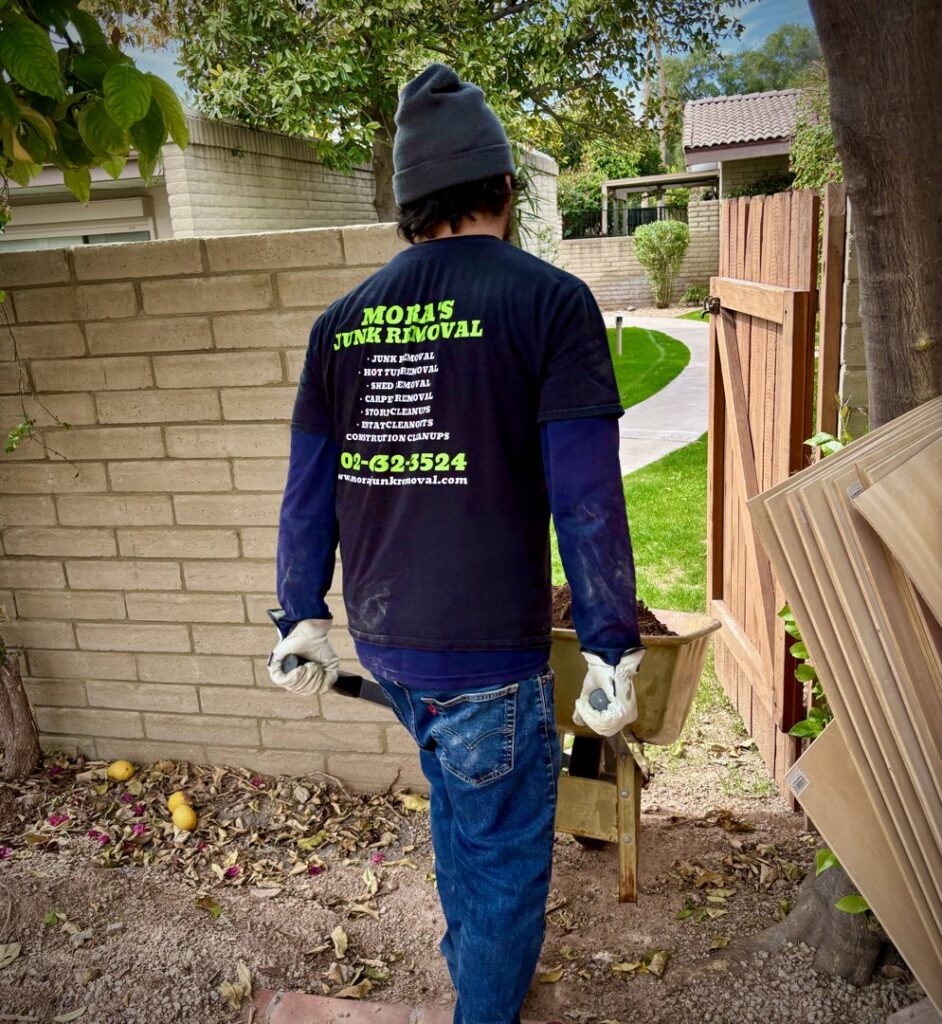 A Mora's Junk Removal & Hauling llc. worker moving debris with a wheelbarrow at a job site in Scottsdale, AZ