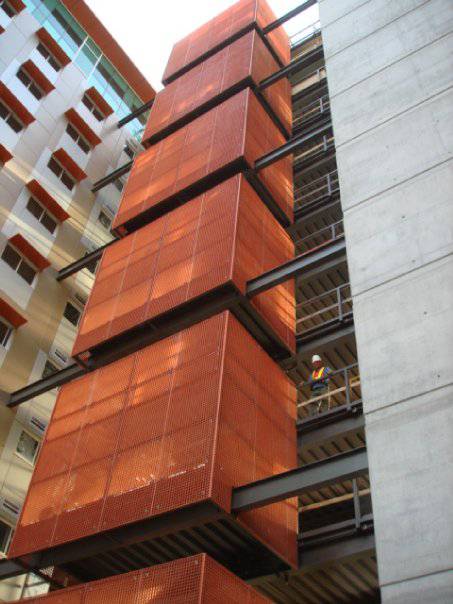 A worker in a hard hat performing maintenance on a commercial building structure for Diamond Ridge Development Corporation in Glendale, AZ.