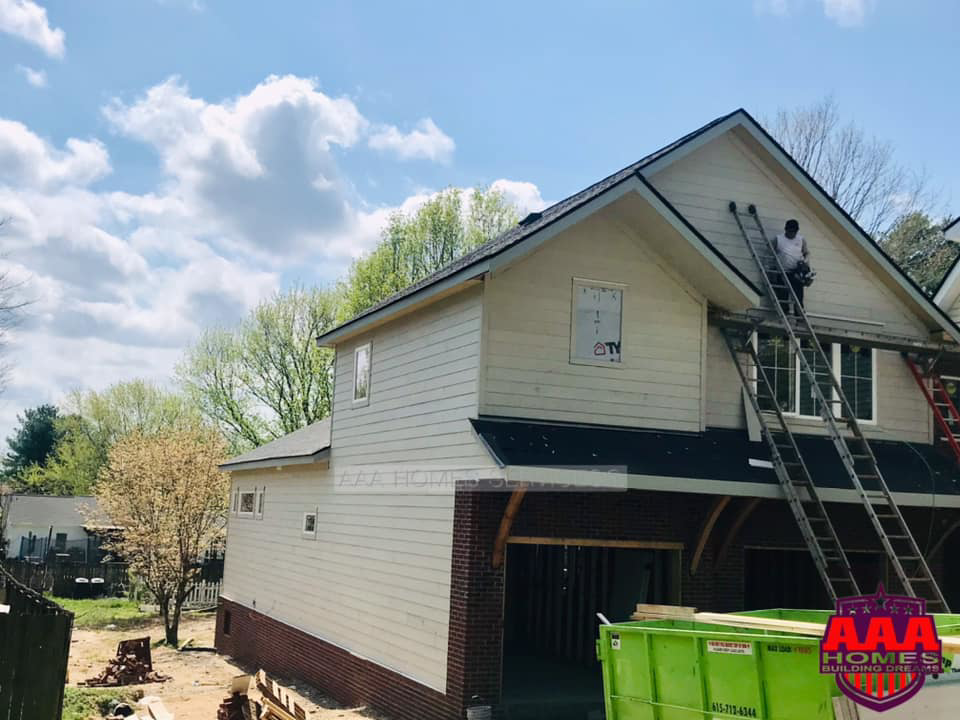 A handyman on a ladder performing exterior home repair and renovation for AAA HOMES LLC in Franklin, TN.