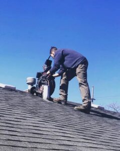 A worker on a roof operating equipment, performing a service for Hessville Plumbing in Hammond, IN.