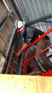 A worker on a scissor lift installing interior wall structure for Valiant Electric Inc. in Kenosha, WI.