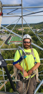 A skilled worker in safety gear performing an inspection on a tower for Fuellgraf Chimney & Tower in Nashville, TN.