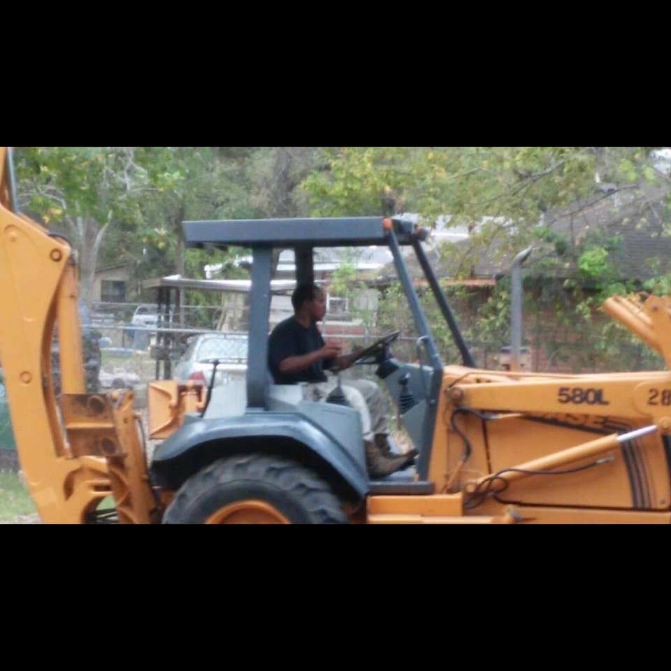 A worker operating a backhoe at a construction site for All Aboard Contractors in Houston, TX.