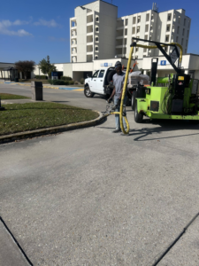 A worker operating a concrete crack sealing machine for Gulf Coast Foundation Solutions in Lafayette, LA