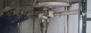 A worker operating a concrete cutting and drilling machine on a wall for Capitol Drilling & Sawing Of Kentucky in Elizabethtown, KY.
