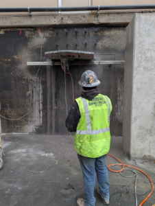 A worker in a safety vest operating a concrete wall saw for Interstate Sawing & Drilling in Yakima, WA.