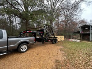A worker from Curry Dumpster Rentals LLC operating the lift mechanism to deploy a dumpster for junk removal in Southaven, MS.