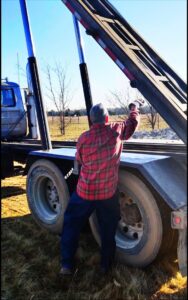 A FJD Waste Disposal and Recycling LLC worker operating the controls of a truck to manage a dumpster for junk removal in Dallas, TX.