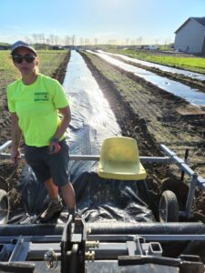 A worker operating a tree planting machine to lay ground cover for tree rows by Tree Rows 4 U in Bismarck, ND.