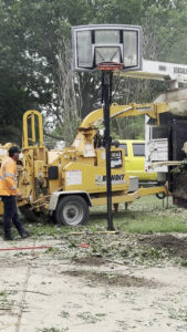 A worker operating a wood chipper to process tree debris for Parker TX Tree Service in Plano, TX.