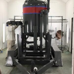 A worker painting a large industrial vessel inside a spray booth for Alpine Painting and Sandblasting Contractors in Paterson, NJ.
