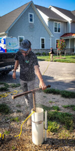 A worker performing well pump testing with water spraying out for S & L Water Solutions in Hagerstown, MD.