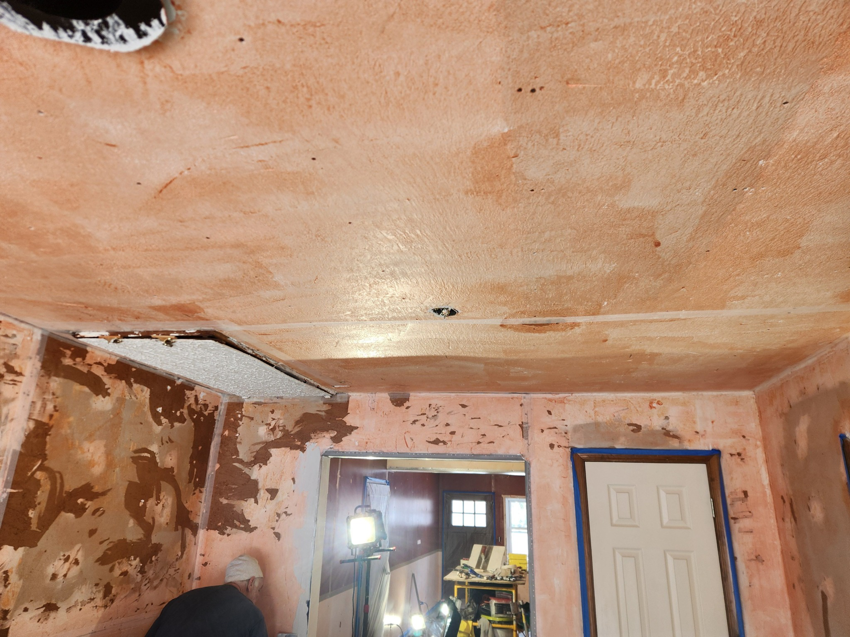 A worker performing wall and ceiling plastering repair by Collins Plastering in Deland, FL