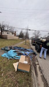 A 614junkremoval worker collecting a pile of curbside junk and debris with their truck and trailer in Columbus, OH.