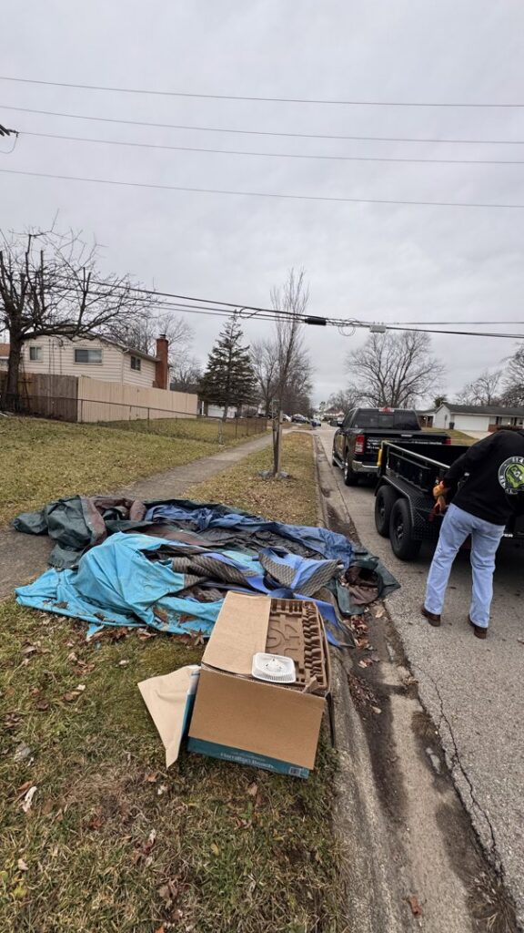 A 614junkremoval worker collecting a pile of curbside junk and debris with their truck and trailer in Columbus, OH.