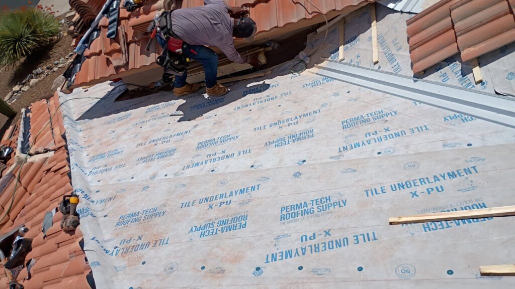 A handyman from Mayitos roofing LLC performing a tile roof repair in Tucson, AZ.