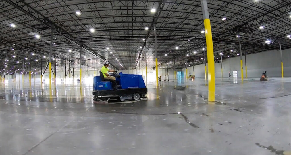 A worker operating a ride-on floor cleaning and polishing machine for Heavy Duty Floors, LLC in New Britain, CT.