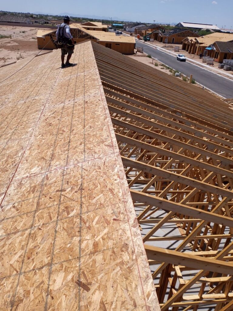 A worker installing OSB sheathing on a roof during construction by AZ Framing and Remodeling in Peoria, AZ
