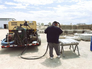 A worker sandblasting a concrete surface for finishing at Arco Concrete Inc in Fort Lupton, CO