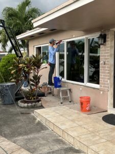 A worker sealing around newly installed windows on a home by FHIA Remodeling in Fort Lauderdale, FL