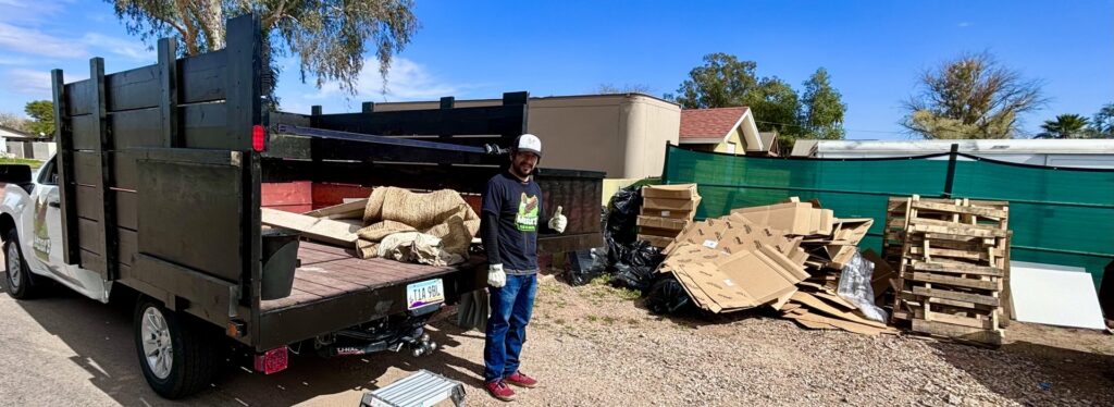 A Mora's Junk Removal & Hauling llc. worker giving a thumbs up next to a truck loaded with junk in Scottsdale, AZ