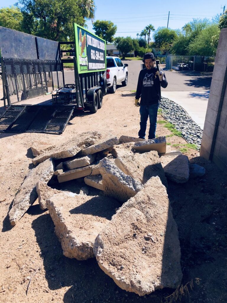A Mora's Junk Removal & Hauling llc. worker giving a thumbs up next to a truck loaded with junk in Scottsdale, AZ