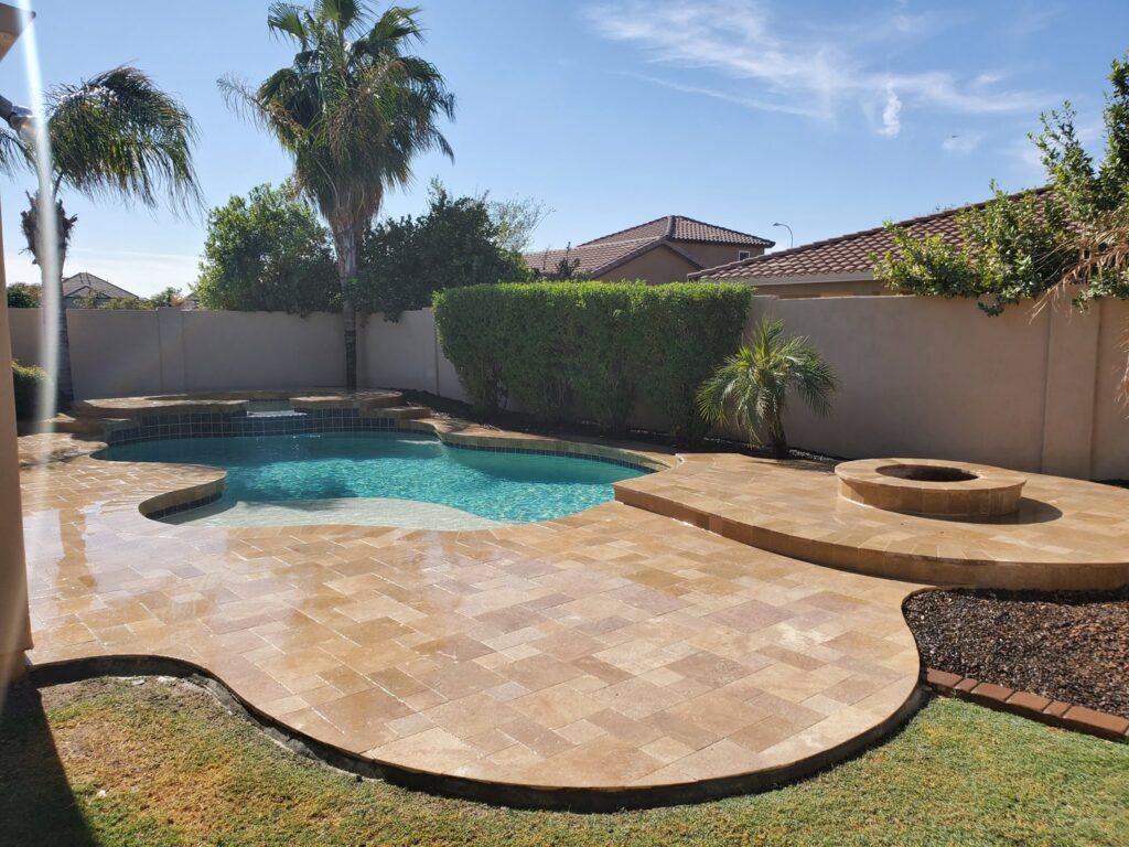 A worker carefully tiling the side of a pool during a renovation project by Aqua Squad Pools & Landscaping in Gilbert, AZ.