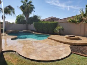 A worker carefully tiling the side of a pool during a renovation project by Aqua Squad Pools & Landscaping in Gilbert, AZ.