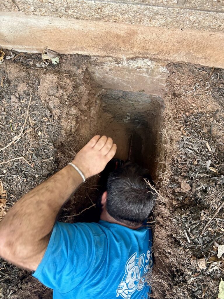 A worker in a trench performing plumbing installation or repair for Ready & Able in Etters, PA.