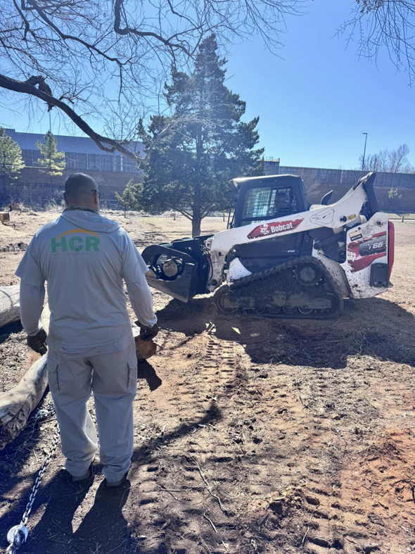 A worker from HCR, Inc. with a Bobcat skid-steer loader on a site preparation job in Boerne, TX.