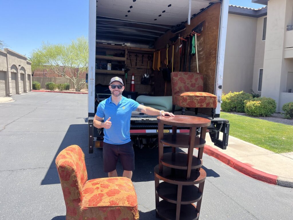 A Happy Hippo Junk Removal worker with furniture ready for pickup in Scottsdale, AZ.