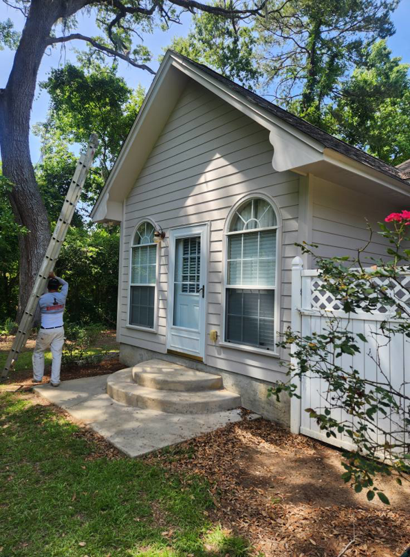 A worker with a ladder preparing for exterior house painting and renovation by Oseguera Painting, LLC in Tallahassee, FL