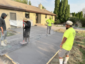 Workers applying a decorative finish to a concrete patio by R&A Concrete Home Solutions LLC in Appleton, WI.