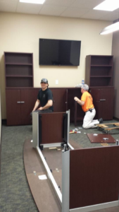 Two workers assembling office furniture and cabinets for a client by DCI - Deason Contracting & Installations in St. Louis, MO
