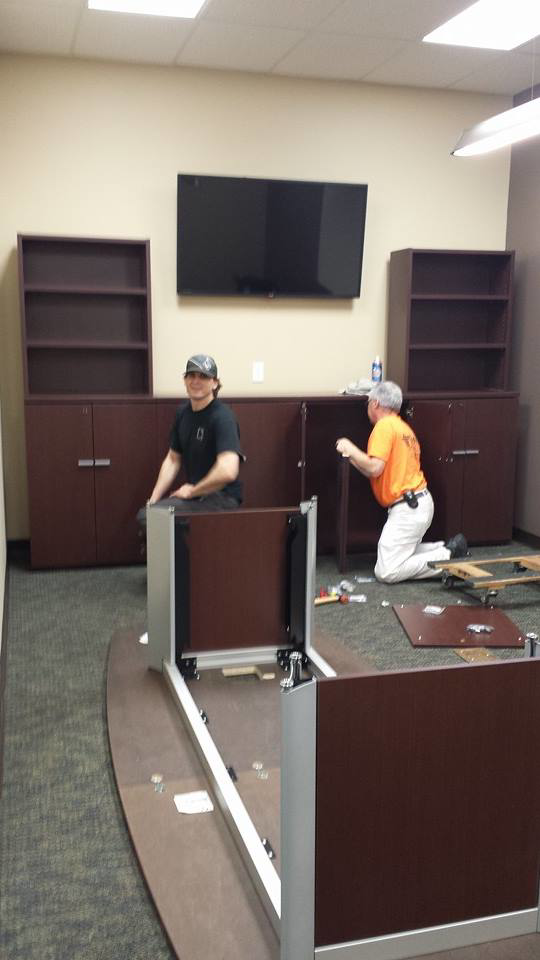 Two workers assembling office furniture and cabinets for a client by DCI - Deason Contracting & Installations in St. Louis, MO