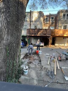 Construction workers breaking up concrete for a trench, showcasing excavation work by MCG General Contractor in Philadelphia, PA.