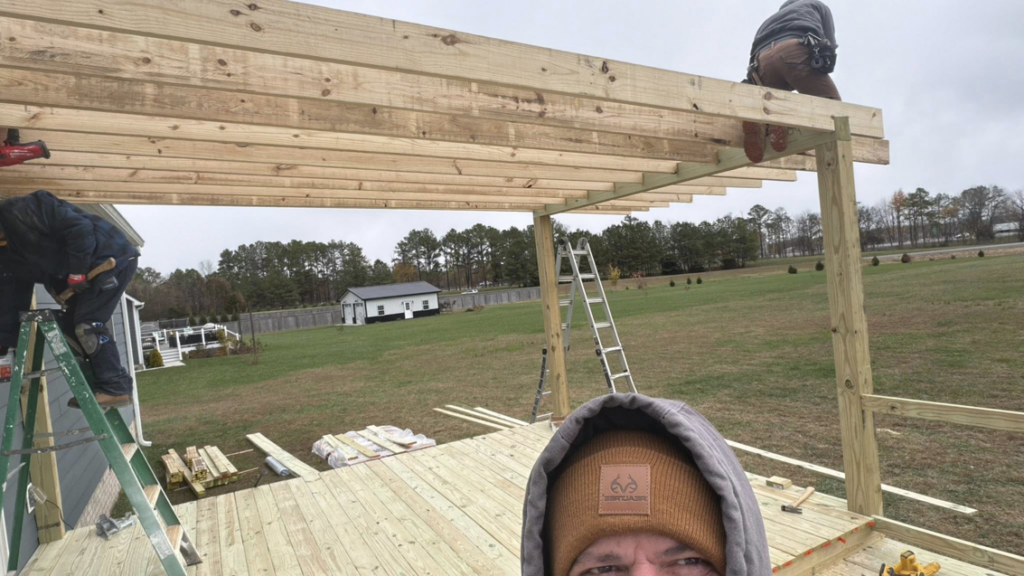 Handyman workers constructing a new wooden deck and pergola for a home, by M&M Handyman Services LLC in Clarksville, TN.