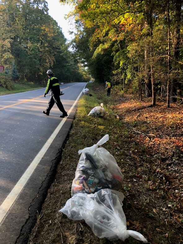 Workers collecting roadside trash and litter in clear bags for Durham County Recycles in Durham, NC