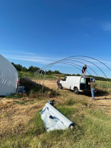 Workers erecting a large hoop structure, possibly for a greenhouse, a construction service by K&K Construction LLC in Enid, OK