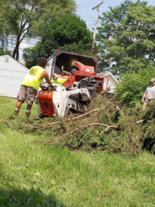 Good Ol' Boys Tree Service workers feeding tree branches into a wood chipper during a job in Lebanon, CT.