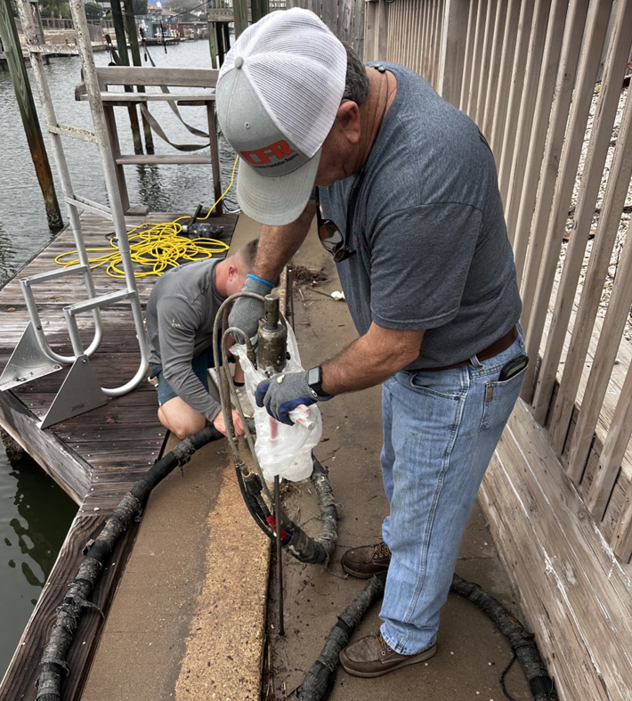 Workers injecting material for dock repair by Complete Foundation Repairs in Corpus Christi, TX.